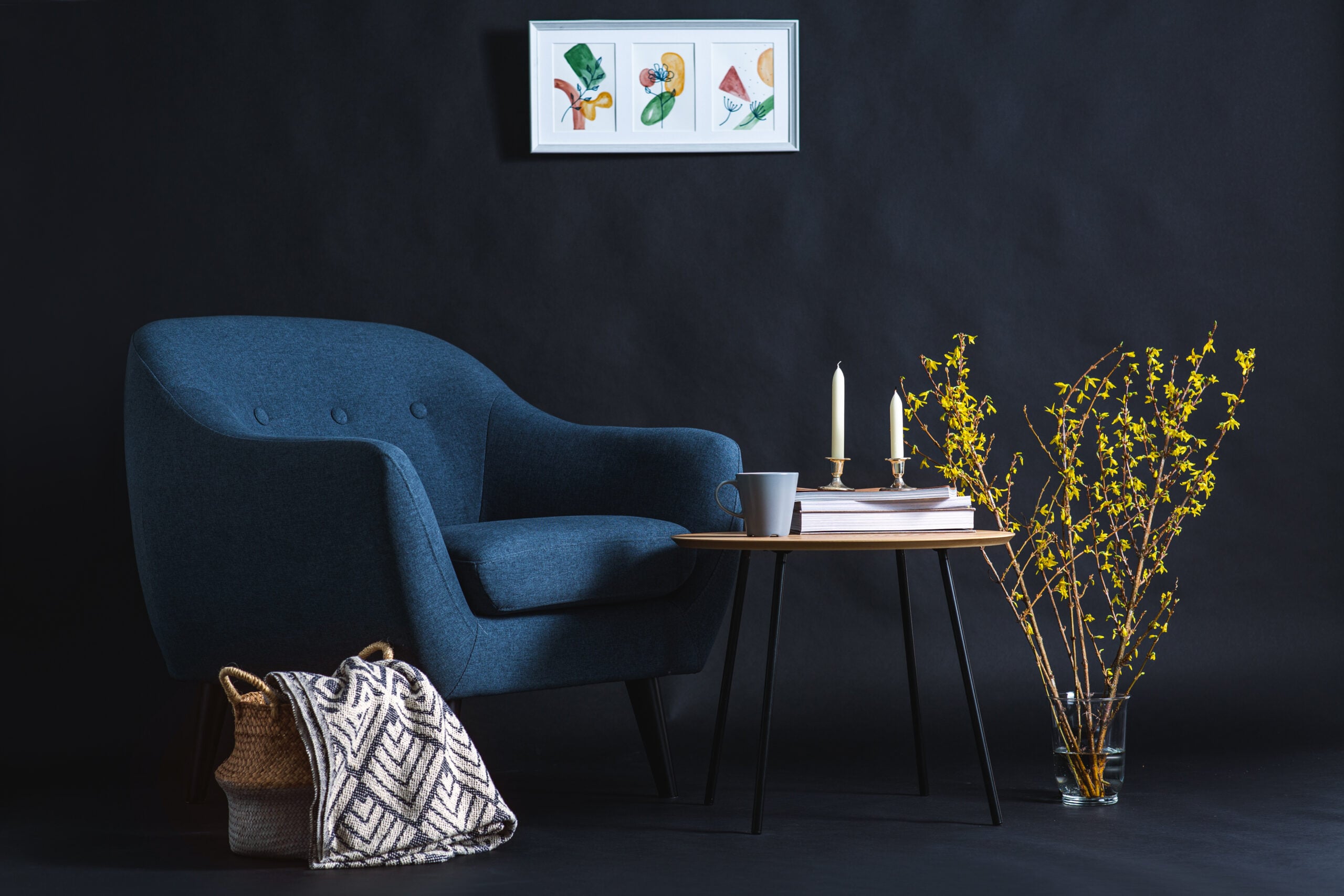A cozy corner with a chair, a folded throw blanket, and a woven basket in soft light