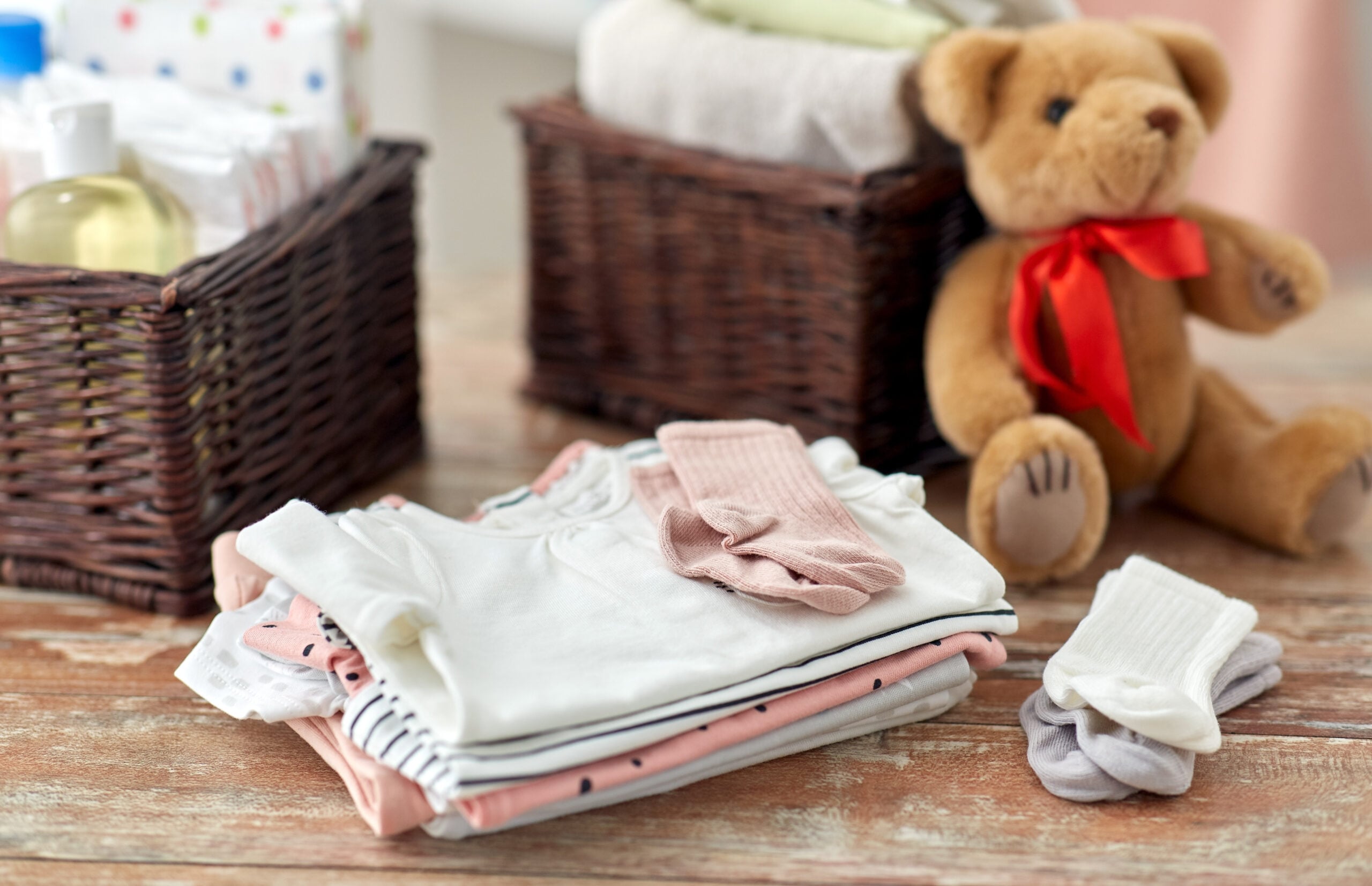 A few simple baby toys and a teddy bear tucked into baskets at home