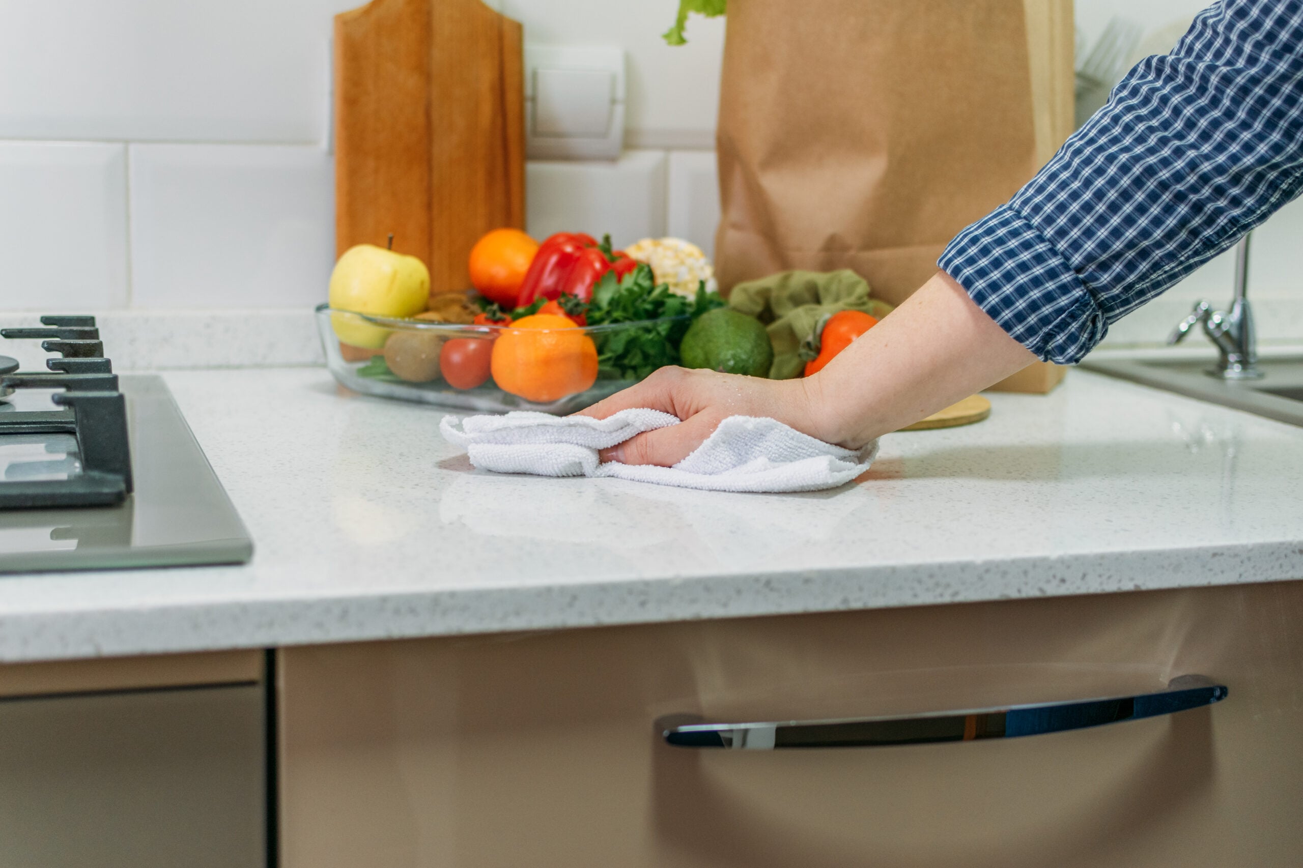 Hand wiping down a kitchen counter with a cloth during a slow cleaning routine