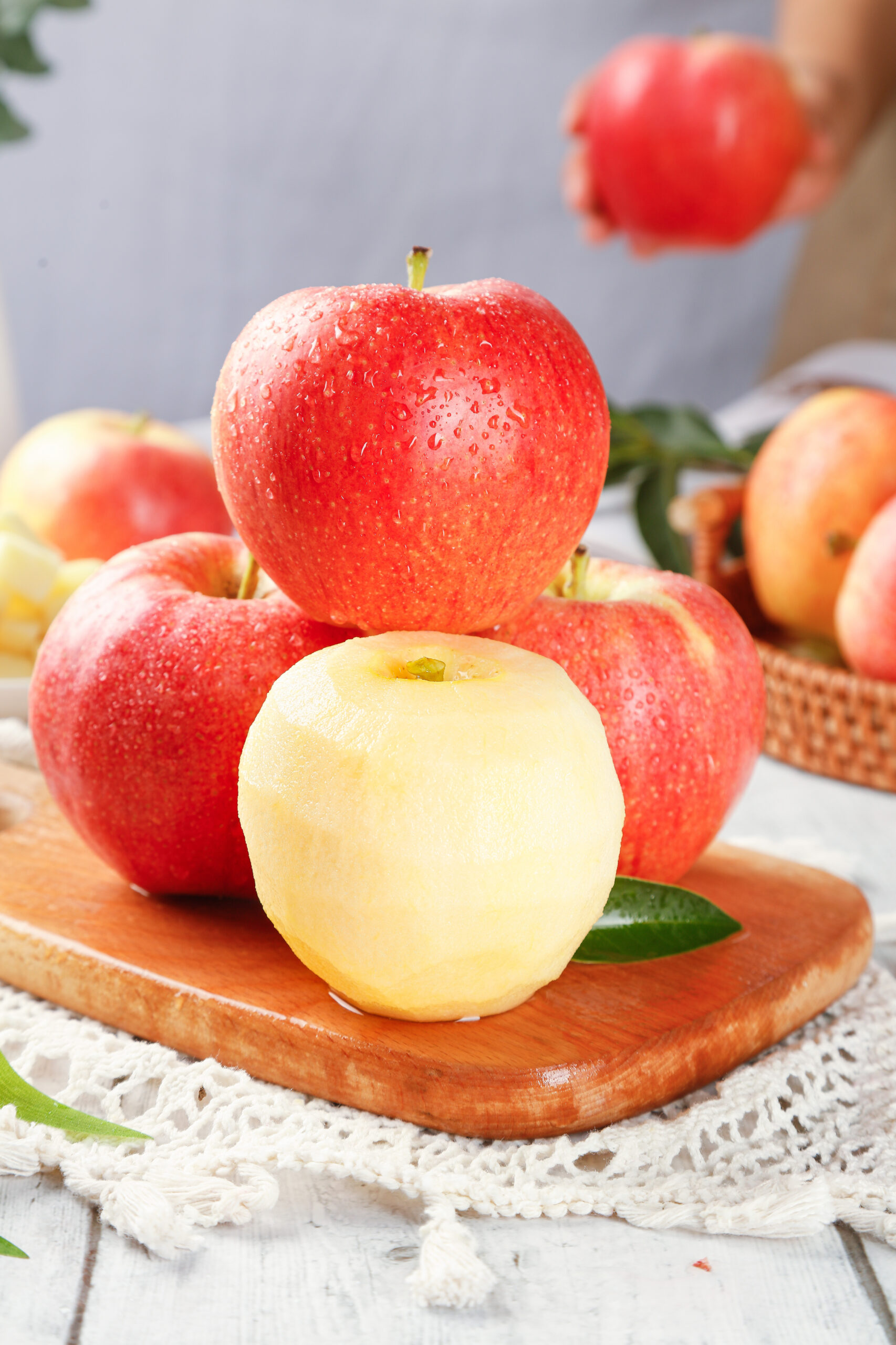 Red Fuji apples on a wooden board with one peeled apple, ready to chop for slow cooker apple butter