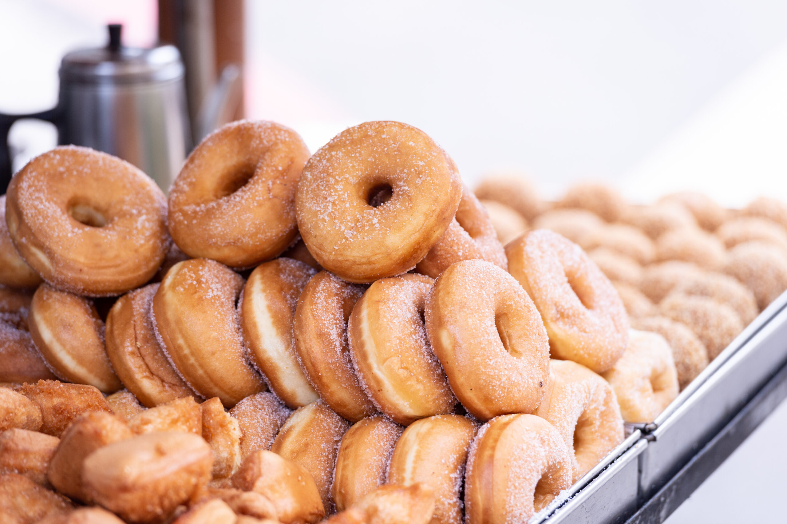 Baked apple cider donuts coated in cinnamon sugar, cooling after coming out of the oven