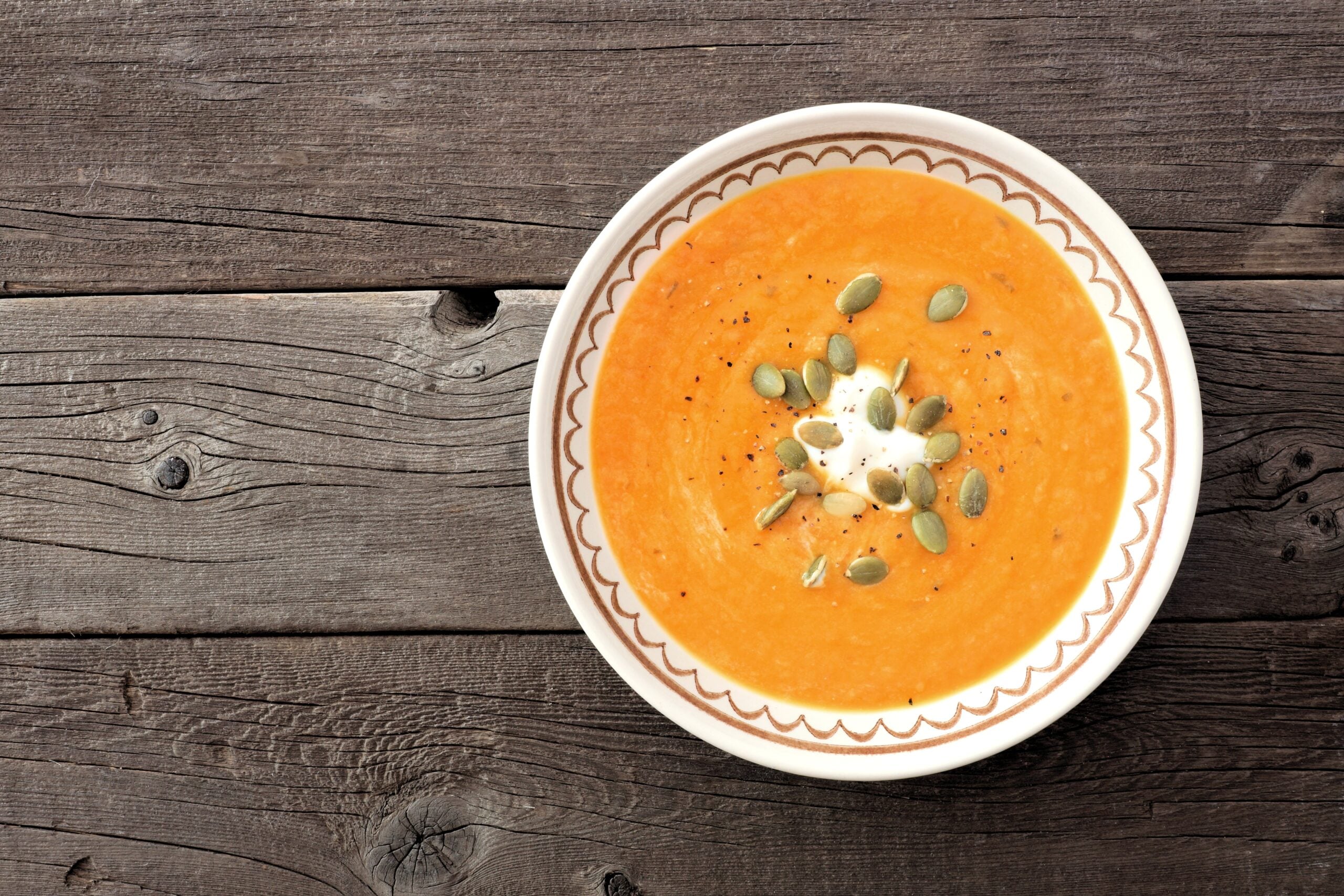 Bowl of creamy butternut squash soup without cream on a rustic wooden table