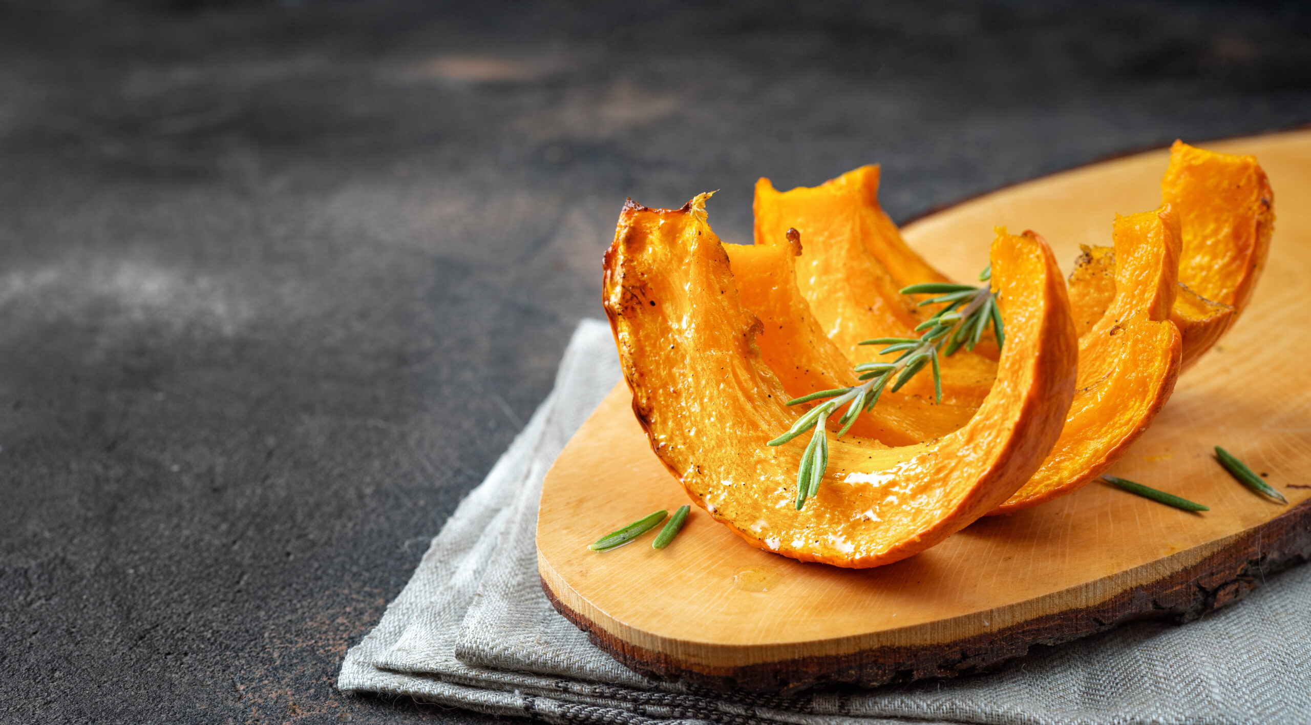 Roasted pumpkin pieces on a wooden tray, cooked soft enough to scoop for pumpkin puree