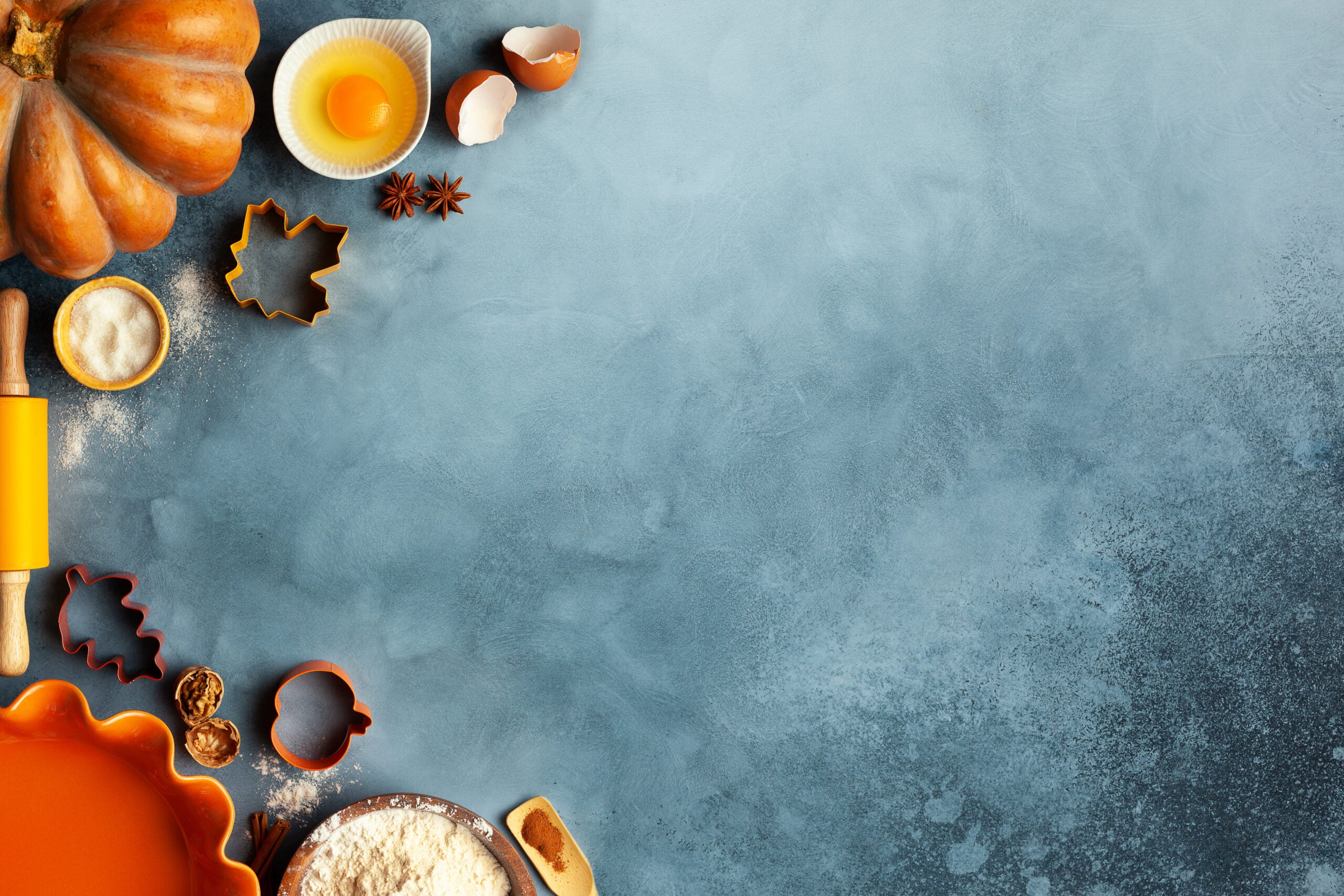 Sugar pumpkins, spices and baking ingredients laid out for making pumpkin bread from scratch