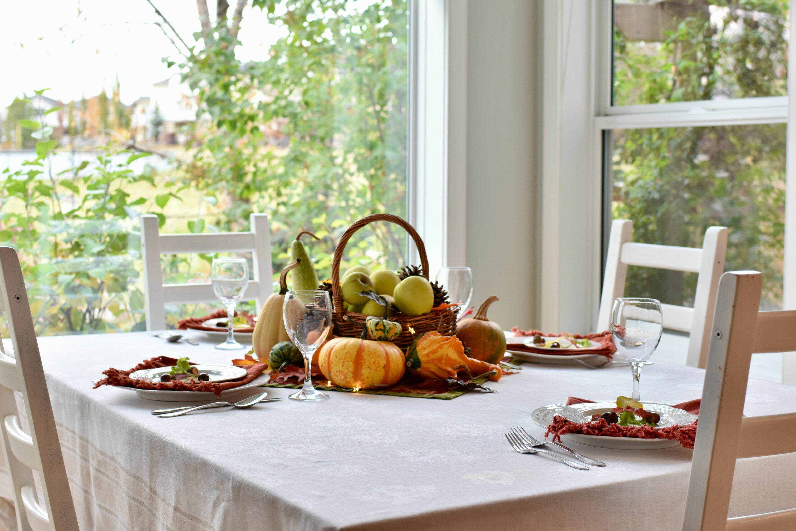 Butternut squash, pumpkins and apples piled on a farmhouse table in early fall