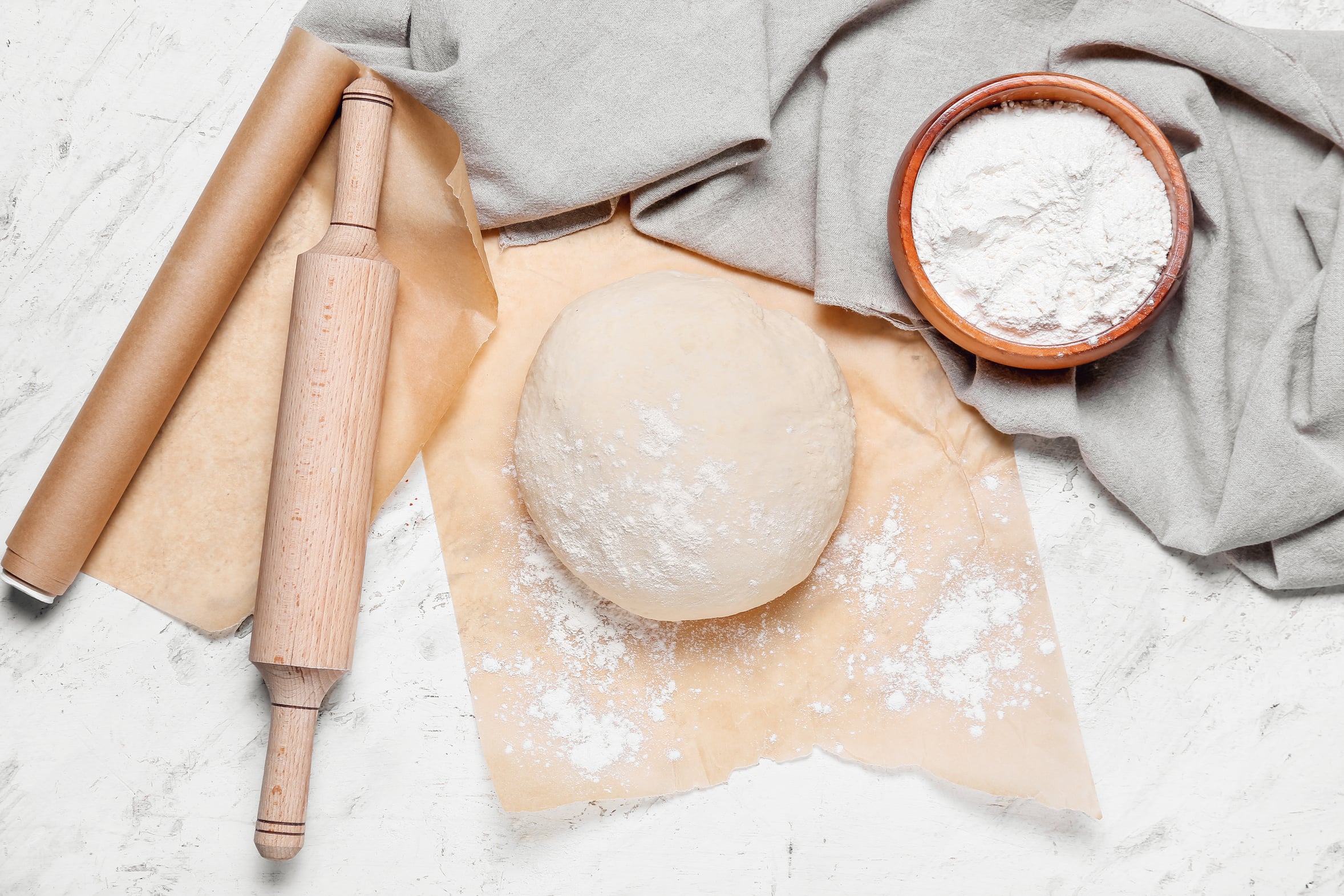 All-butter pie dough with flour and a wooden rolling pin, ready to roll for a pot pie crust