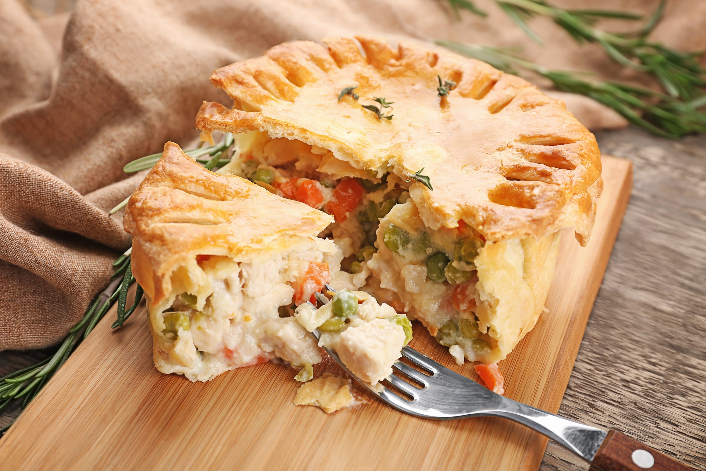 Baked chicken pot pie from scratch with a golden crust, cooling on a wooden board