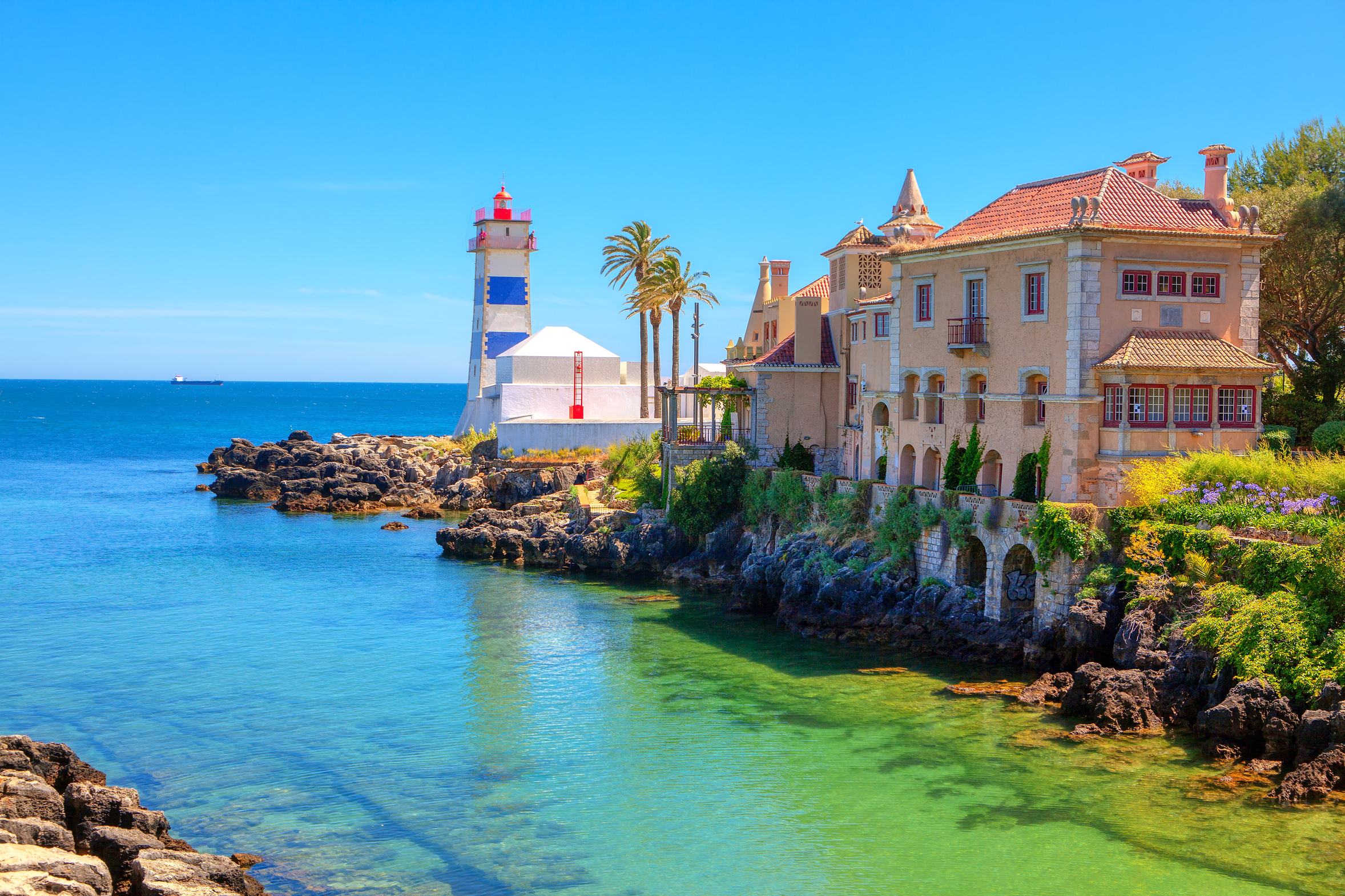 The striped Santa Marta lighthouse and Forte de Santa Marta on the Atlantic shore at Cascais, Portugal