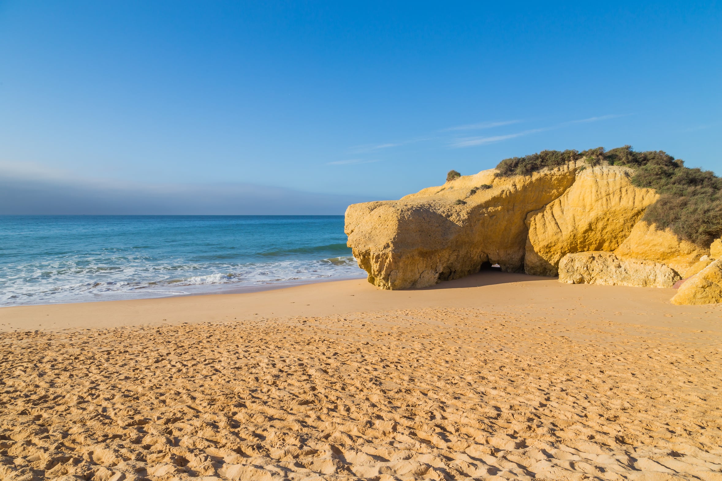 Wide flat sand on an Algarve beach in the morning, the kind of beach Meia Praia in Lagos is
