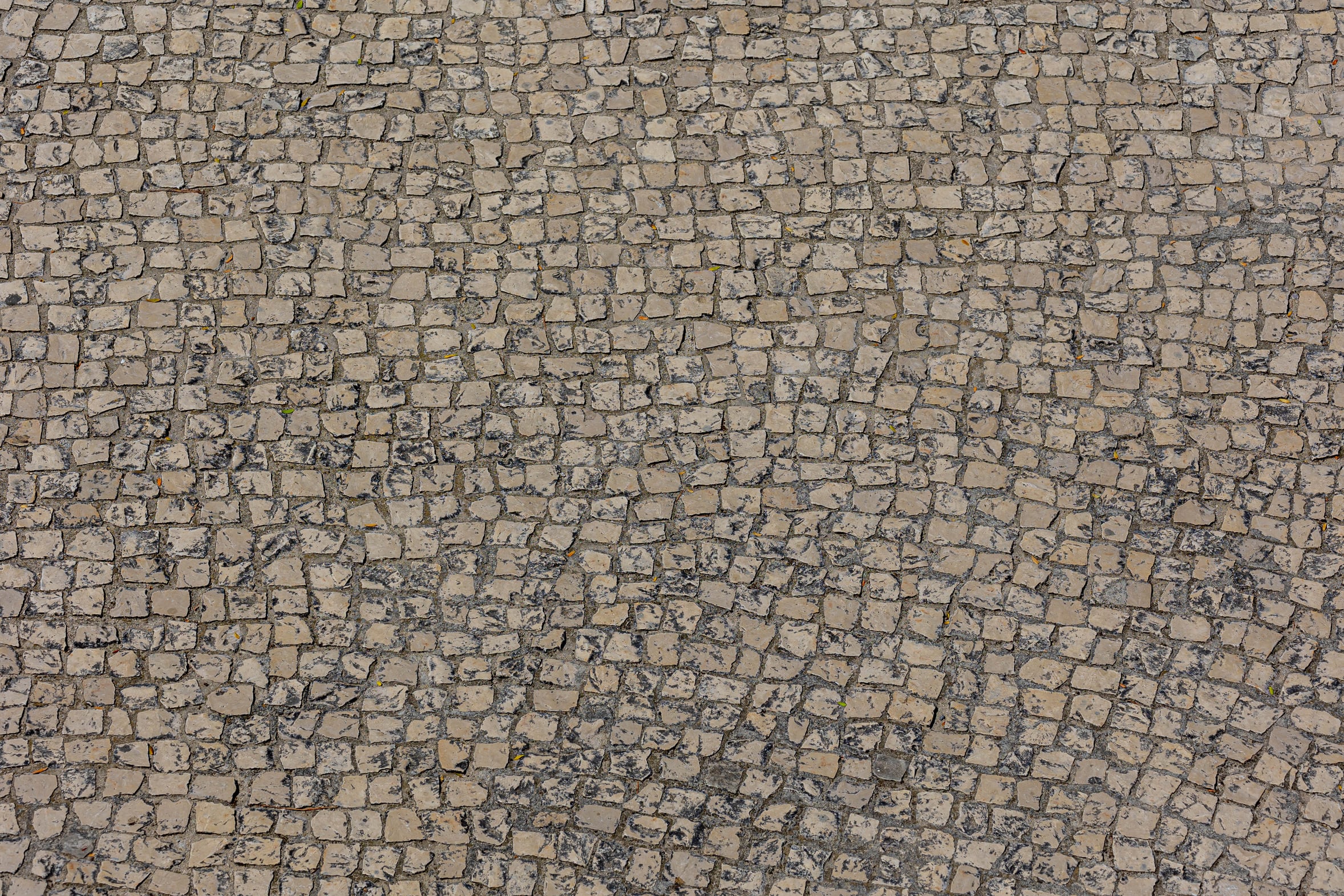 The polished stone calcada pavement of central Lisbon, Portugal, close up