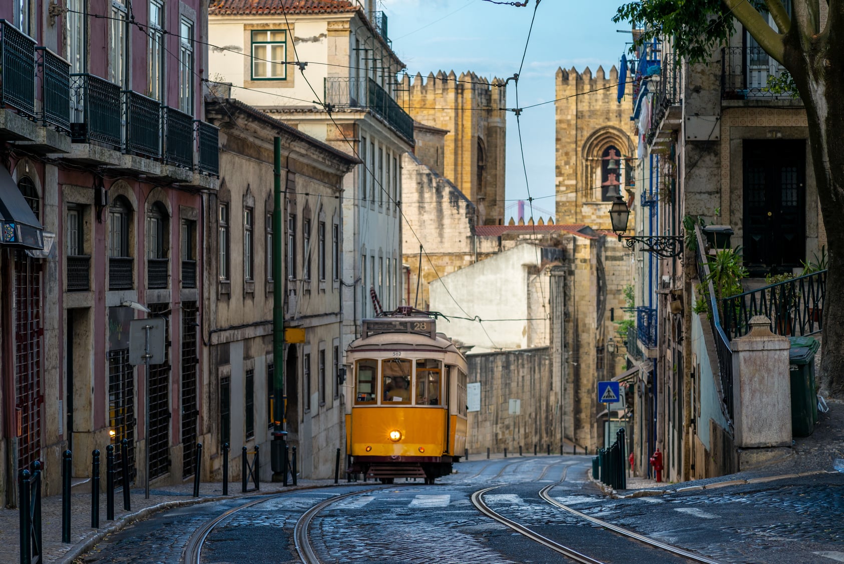 A tram on line 28 on a narrow street in Lisbon, Portugal