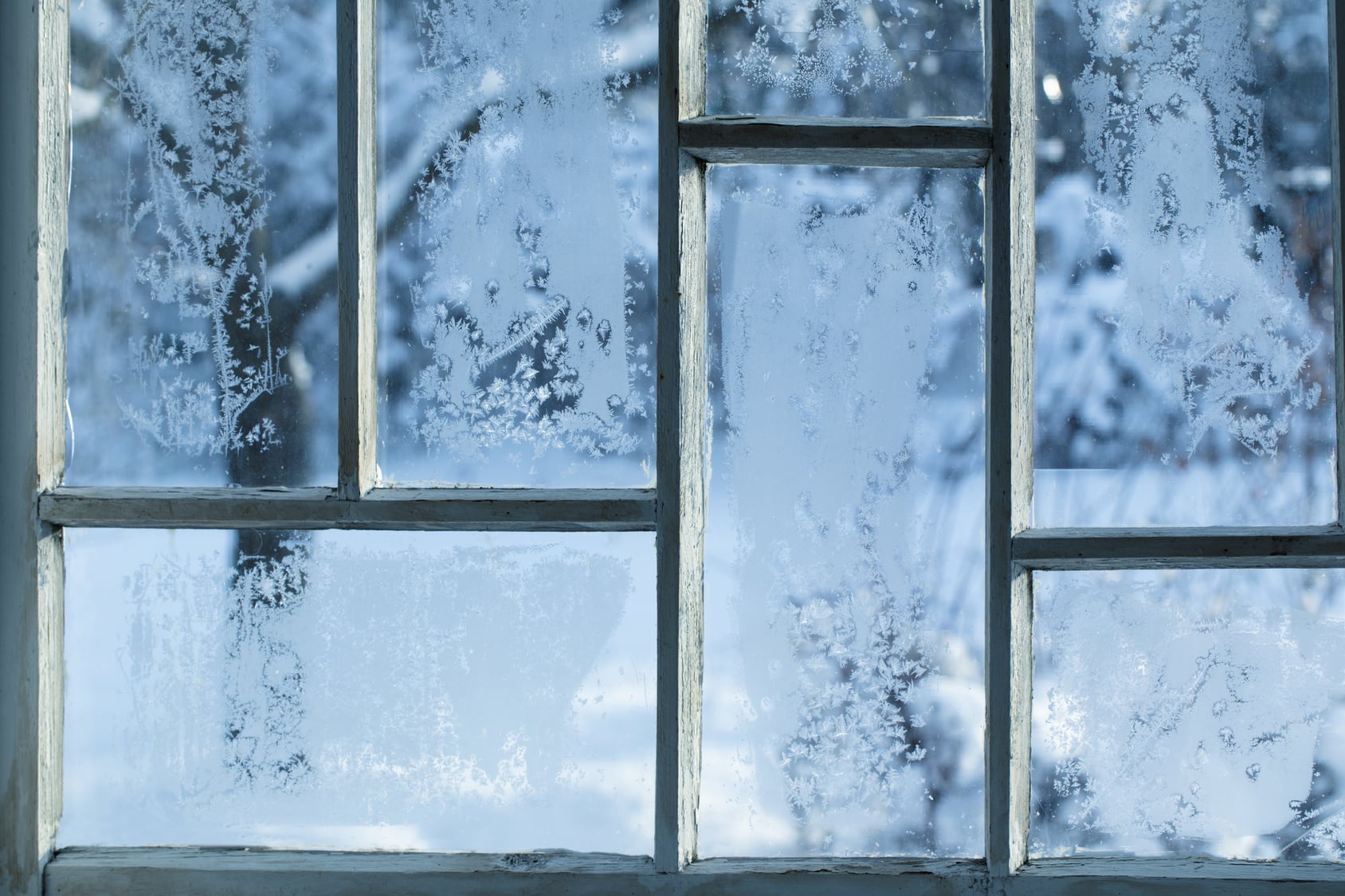 Old wooden window frame in an old house looking out onto snow