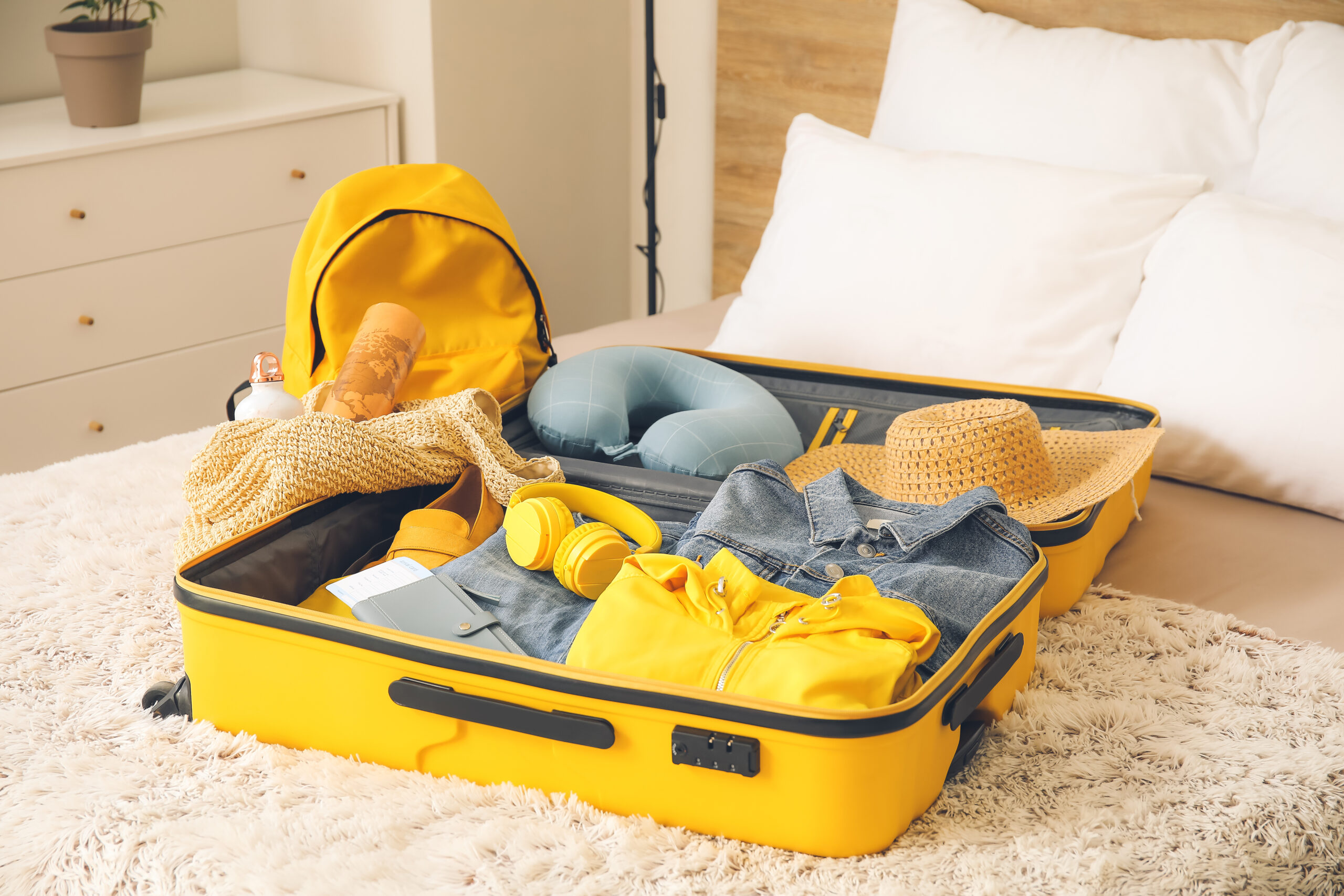 A packed suitcase of folded clothes laid open on a bed before a family trip to Portugal